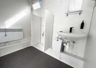 Sanitärcontainer Pissoir mit einem Urinal und einem Waschbecken und Spiegel